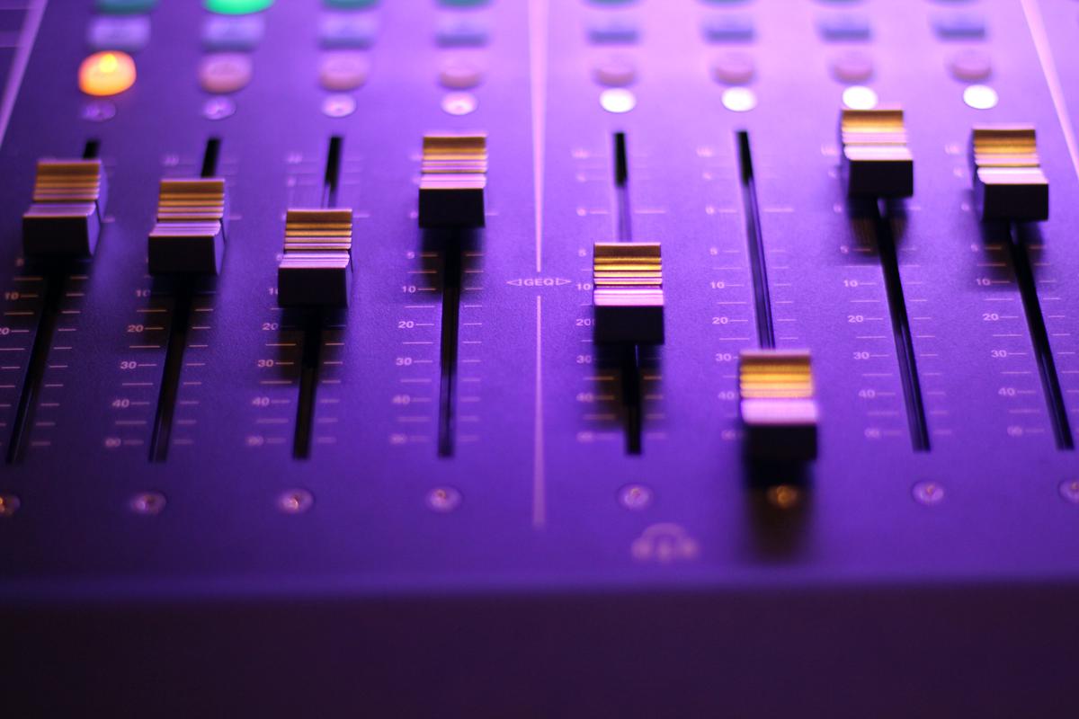 Image showing a person adjusting audio levels on a soundboard